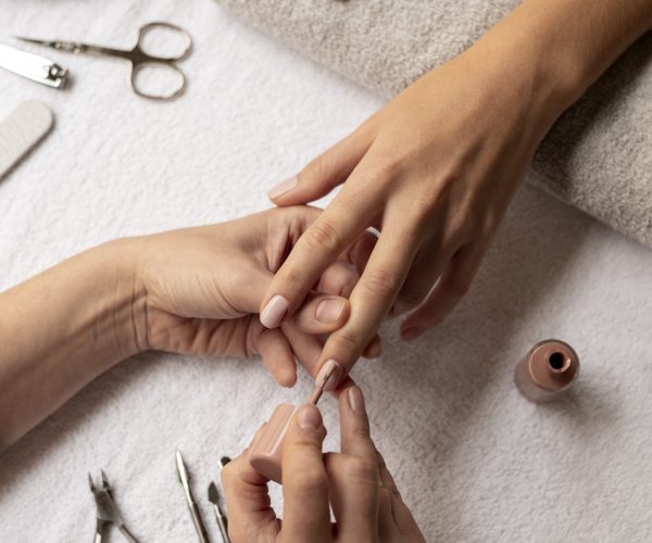 close-up-manicurist-using-nail-polish